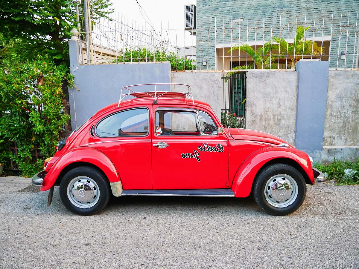 chiang mai red beetle parking in front of house car